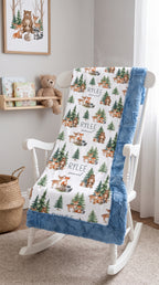 Personalized woodland animal minky blanket with blue trim draped over white rocking chair
