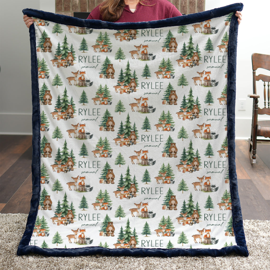 Woman holding personalized woodland animal minky blanket with navy trim