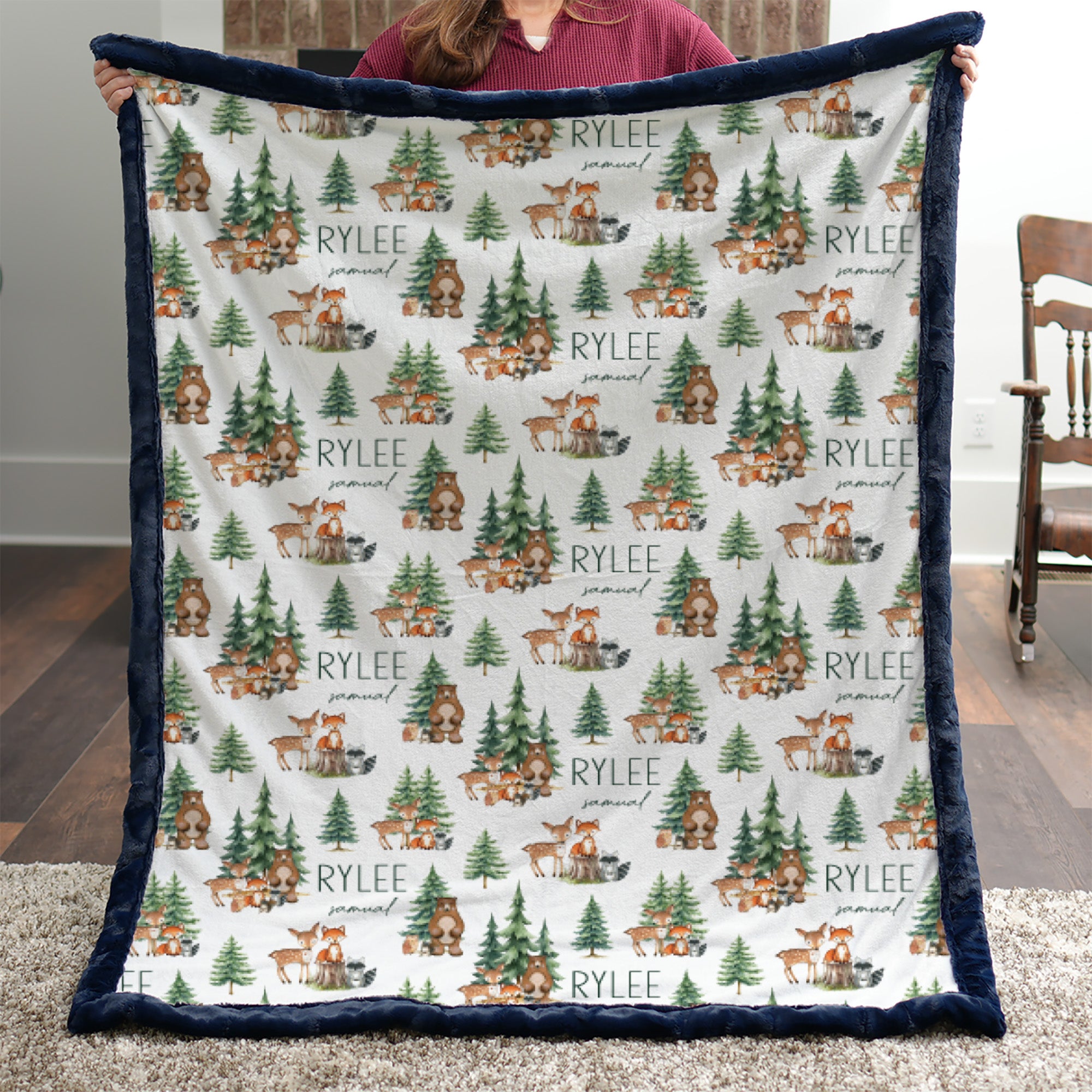 Woman holding personalized woodland animal minky blanket with navy trim