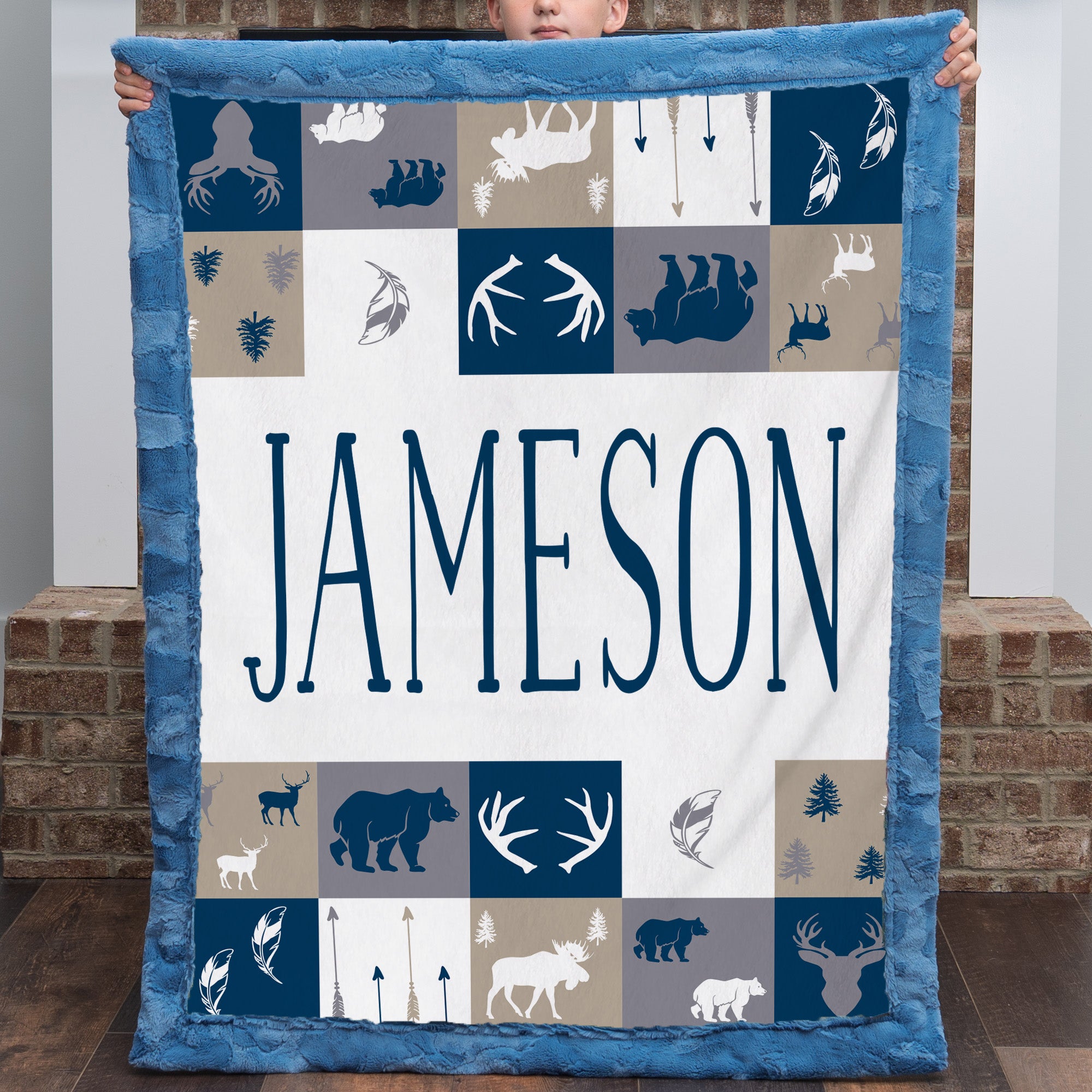 Boy holding personalized woodland minky blanket with blue trim