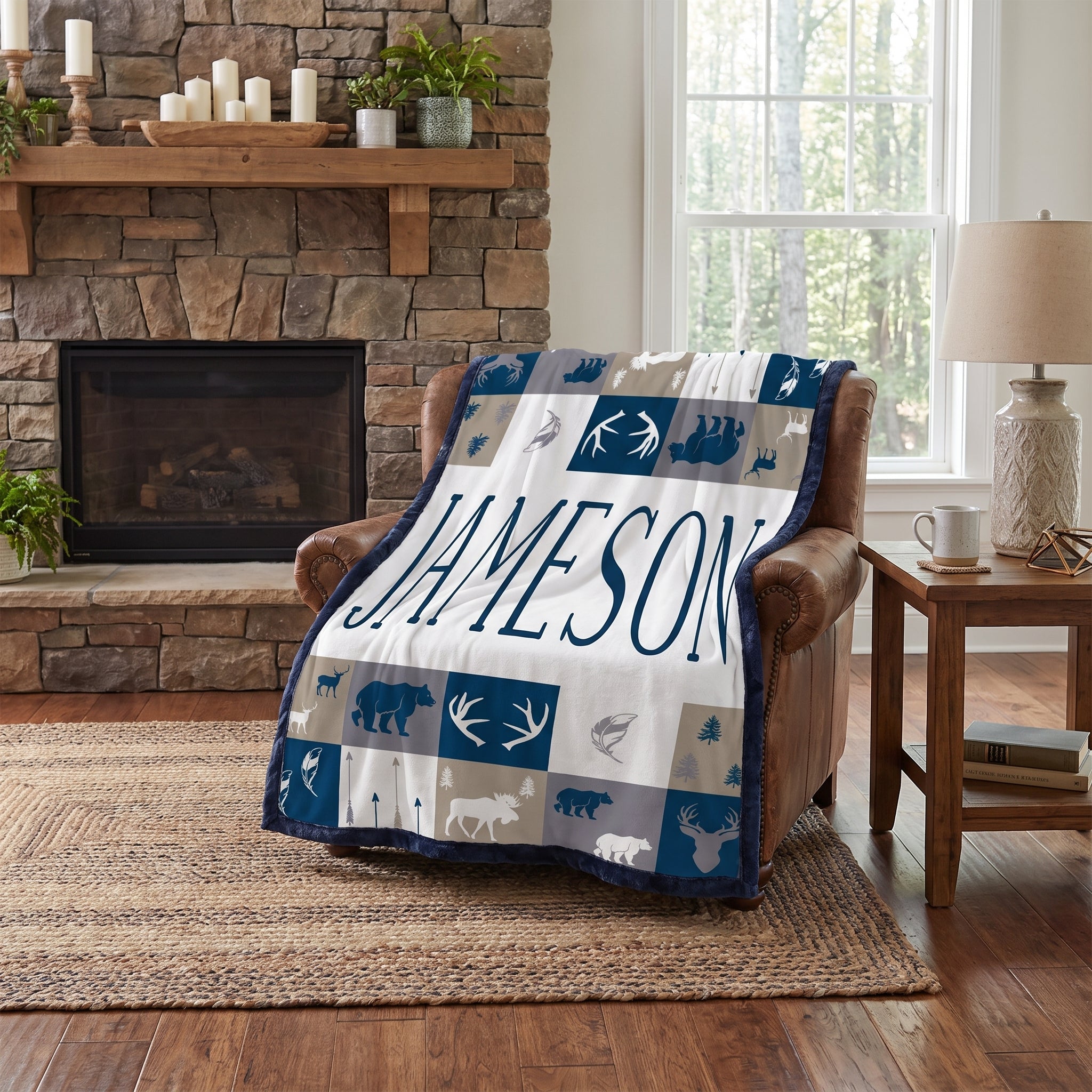 Personalized woodland minky blanket with navy trim draped over leather chair by fireplace
