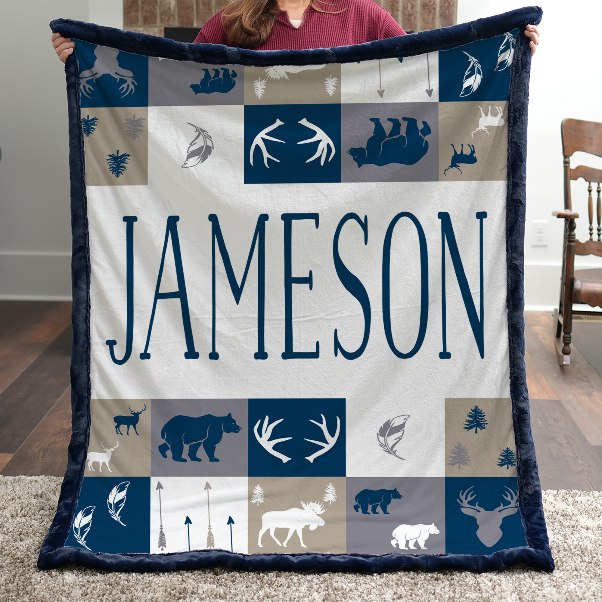 Woman holding personalized woodland minky blanket with navy trim