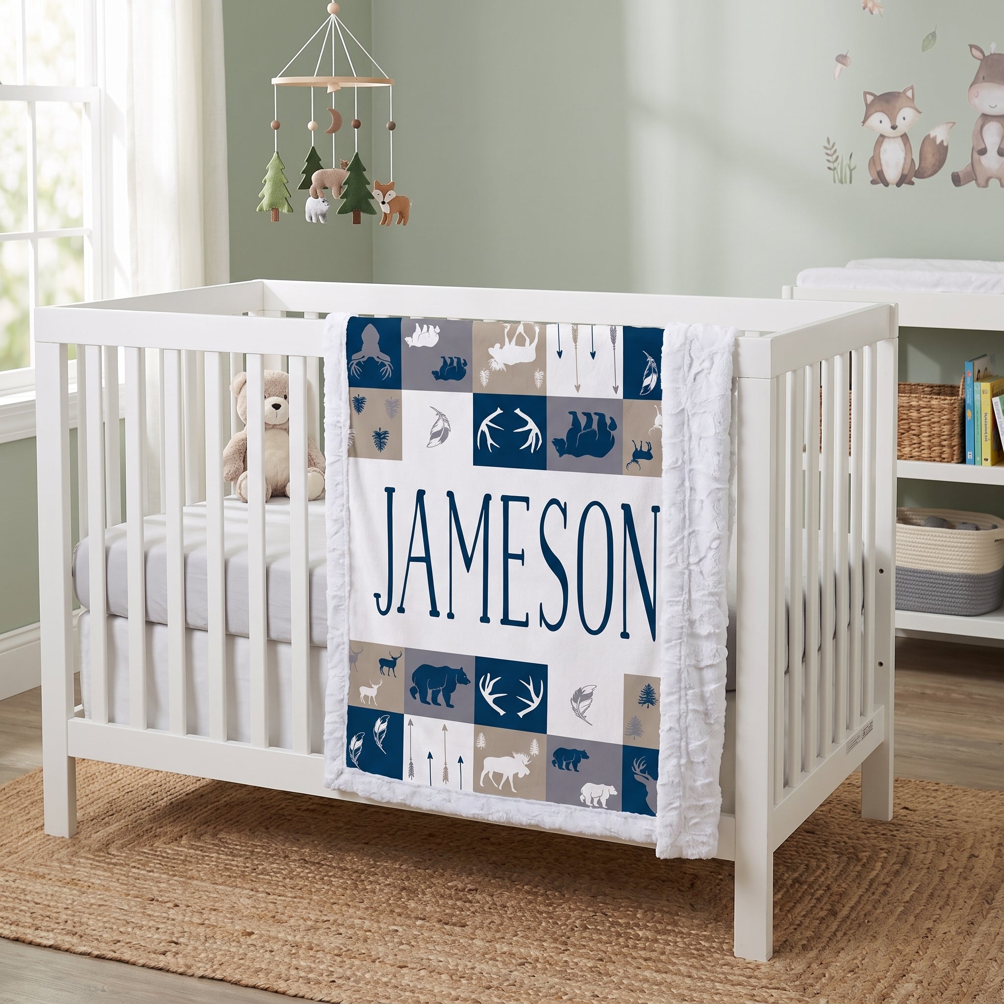 Personalized woodland minky blanket with white sherpa back draped over crib rail