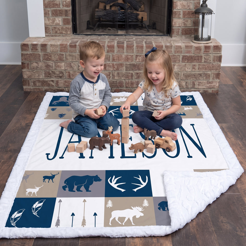 Boy and girl playing with wooden toys on personalized woodland minky blanket by fireplace