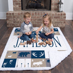 Boy and girl playing with wooden toys on personalized woodland minky blanket by fireplace