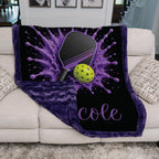 Purple and black personalized pickleball throw blanket draped over a living room couch