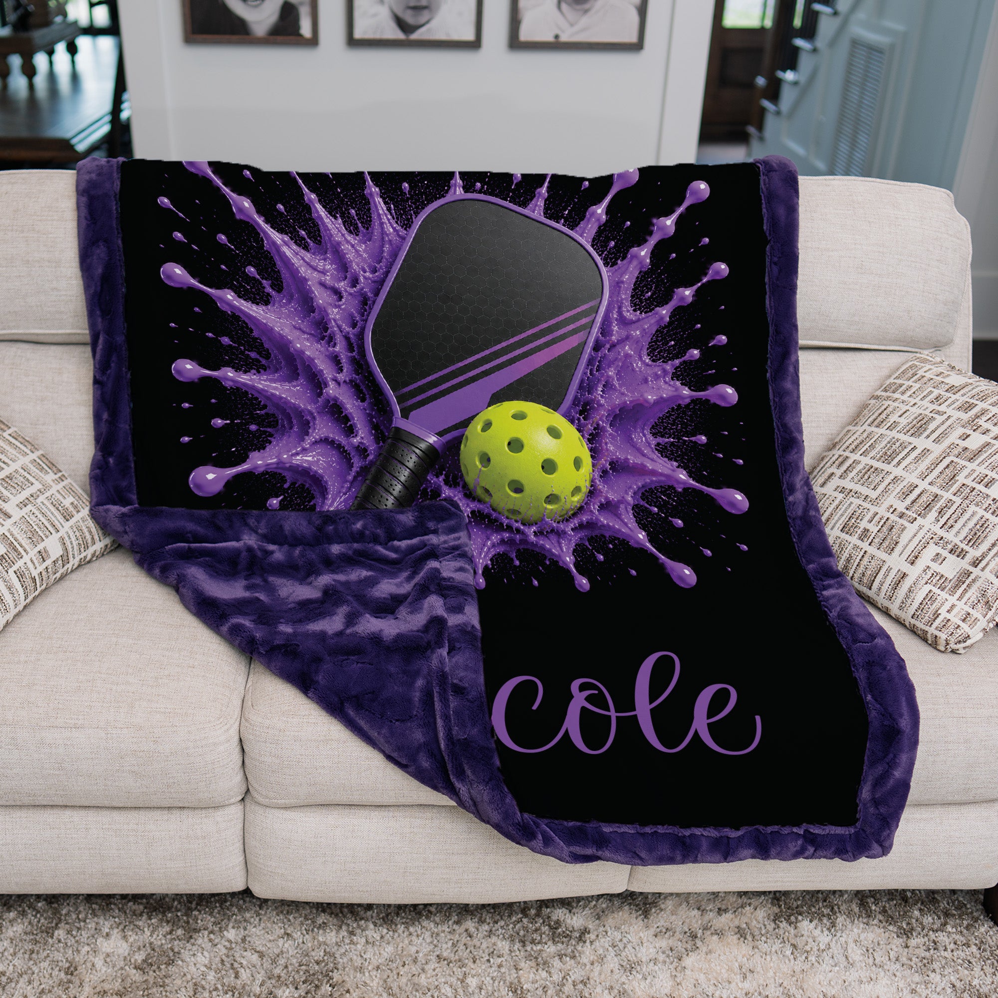 Purple and black personalized pickleball throw blanket draped over a living room couch
