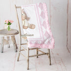 Pink pony minky baby blanket draped over rustic chair, rosette fur backing visible