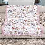Close-up of pink tractor farm animal print with embroidered baby name on minky blanket