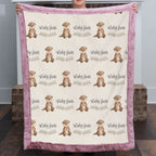A person holds up a personalized baby blanket featuring a repeating pattern of brown otters and the names 'Ruby Jane' on a cream background, with a pink plush border.