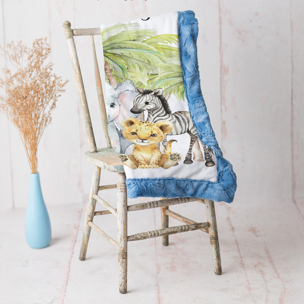 Close-up of safari animal baby blanket corner folded to show blue Luxe Cuddle Minky backing