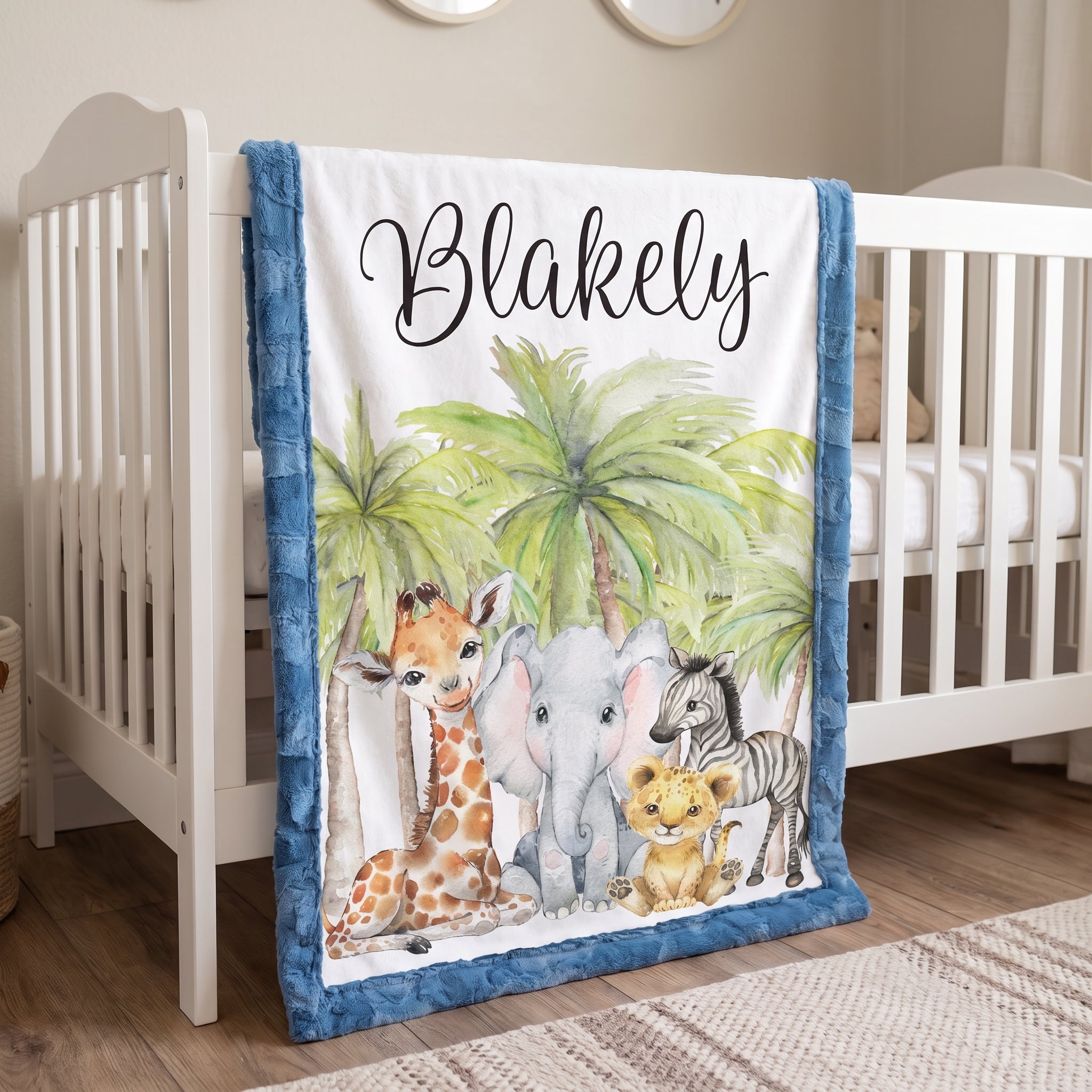 Personalized safari animal baby blanket hanging on crib rail in nursery with round mirrors