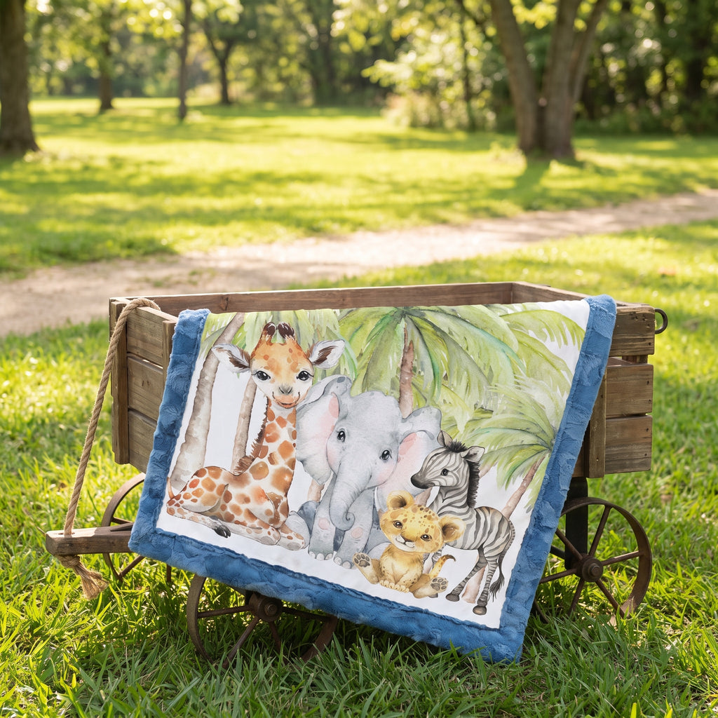 Personalized safari baby blanket draped over wooden wagon in grassy outdoor setting