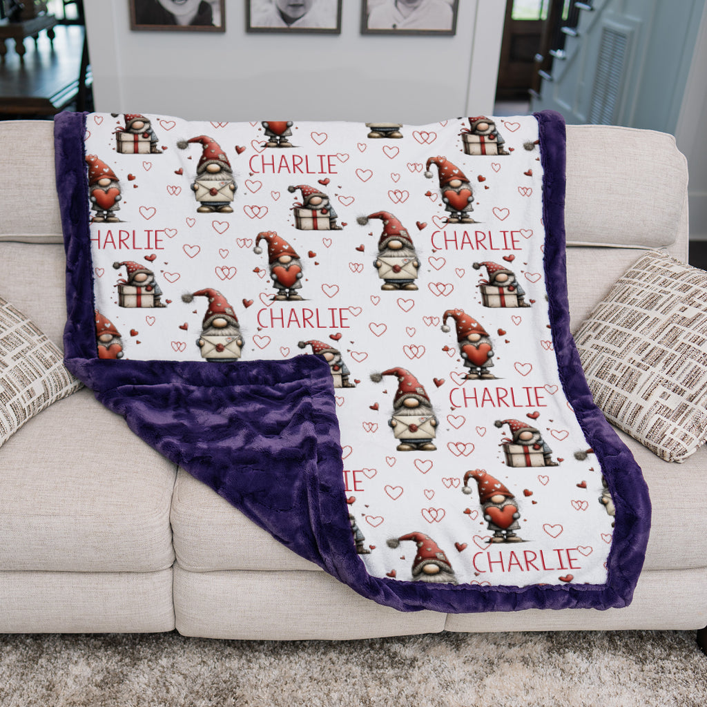 Blanket with gnome pattern and 'Charlie' text on a couch