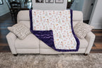 Sofa with a floral-patterned blanket draped over it in a living room setting.