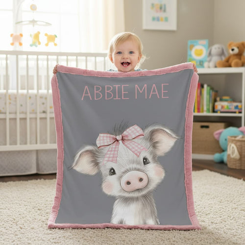 Happy baby holding personalized pig minky blanket in nursery with crib and toys in background