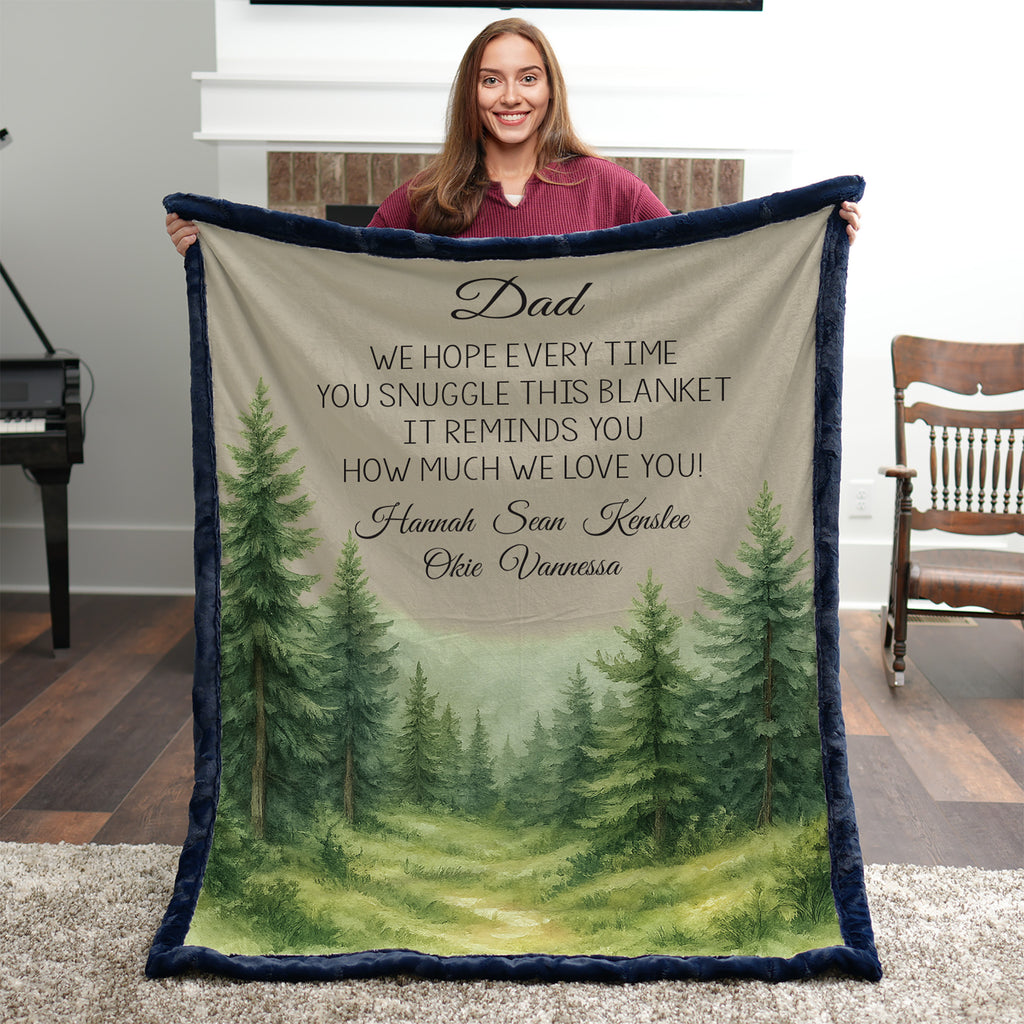 Person holding a blanket with a forest design and personalized text in a room.