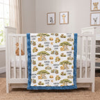 A custom safari-themed baby blanket with the name 'KAYSEN LIAM' printed repeatedly, draped over a white wooden crib in a bright nursery.