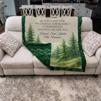 Blanket with tree design and personalized text on a couch in a living room.