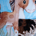 Close-up of a fabric with a horse and giraffe design on a blue background
